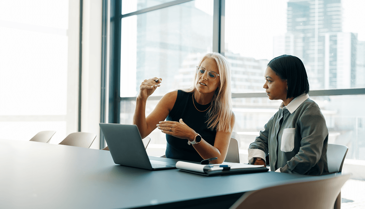 2 women looking at a laptop on a table
