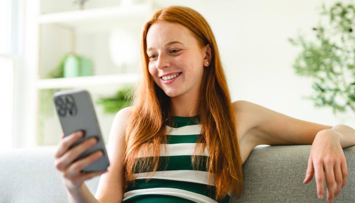 woman smiling looking at her smartphone