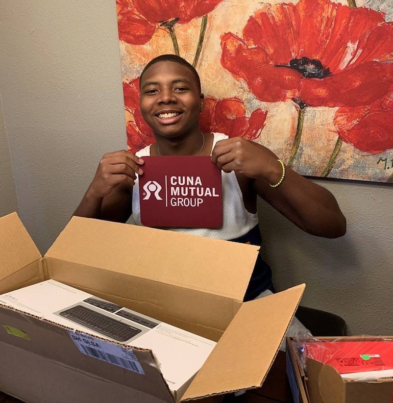 Caleb Fisher holding a CUNA Mutual Group branded item