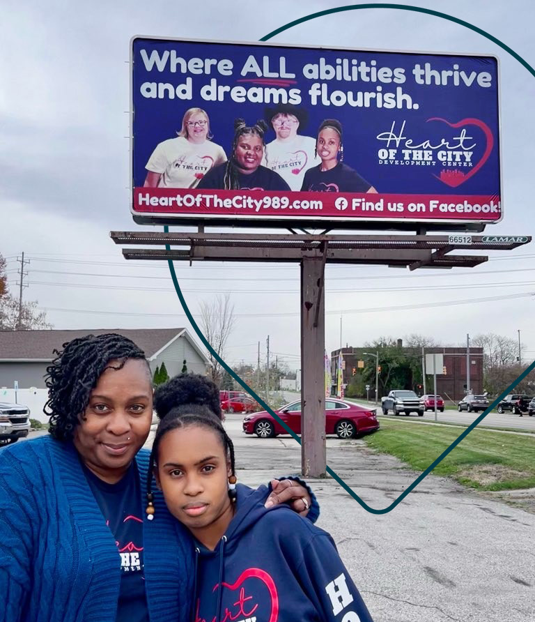 two women in front of billboard