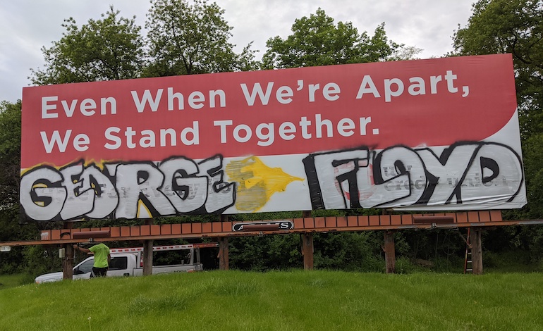 Graffiti of George Floyd’s name on billboard.