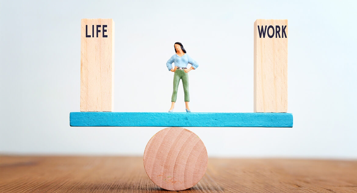 woman balancing work and life blocks on a seesaw