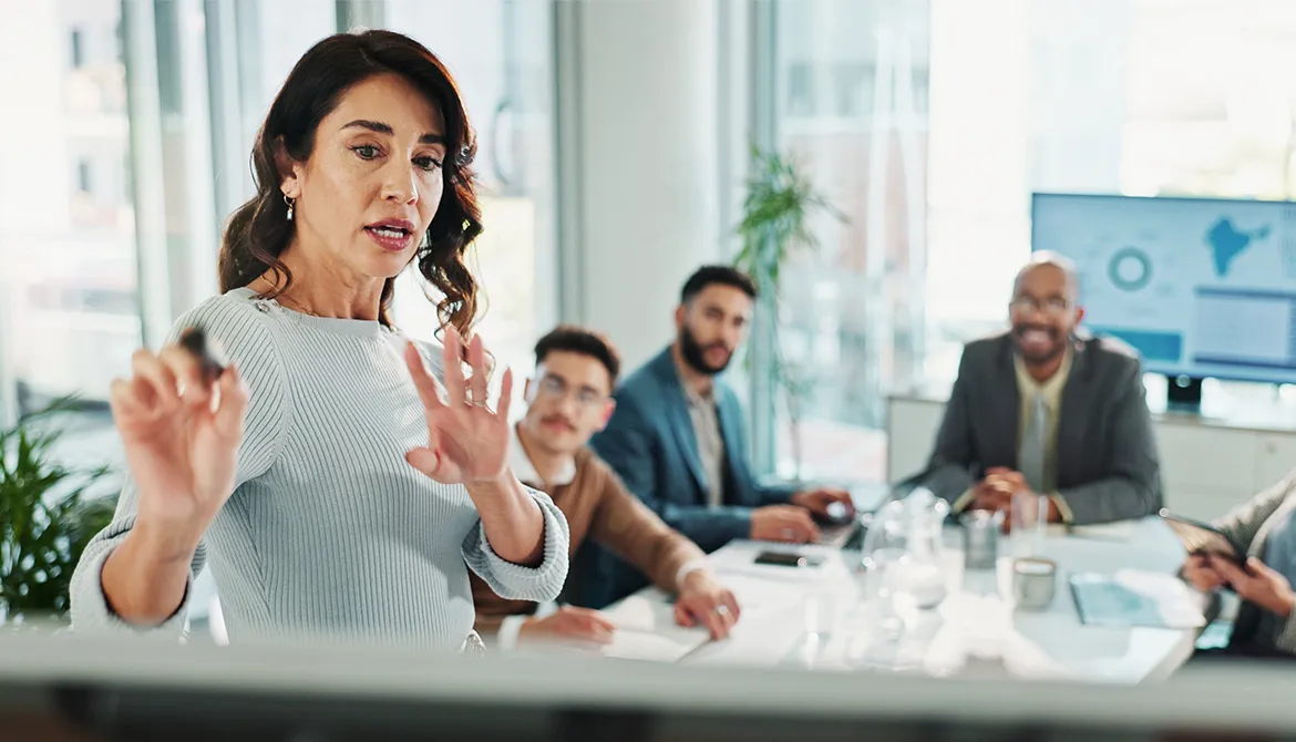 woman explaining to group around table