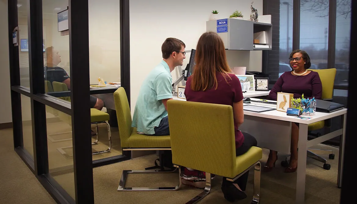 young couple sitting at loan officers desk
