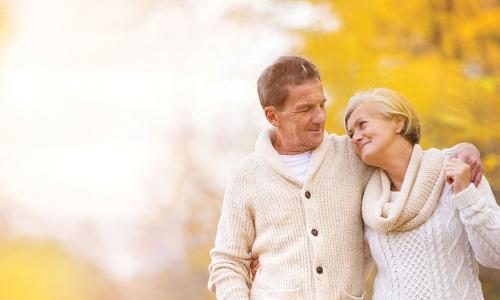 happy retired couple with fall leaves in the background