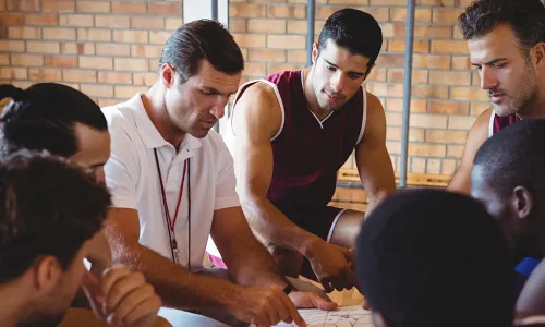 Coach explaining game plan to basketball players in the court