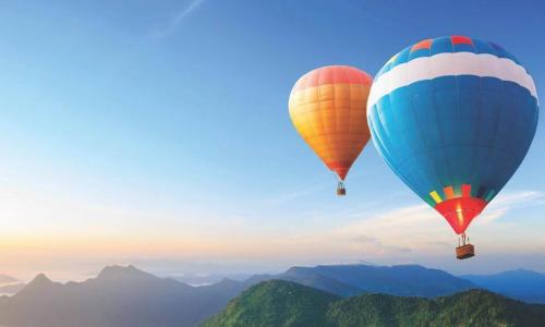 colorful hot air balloons soaring over mountains