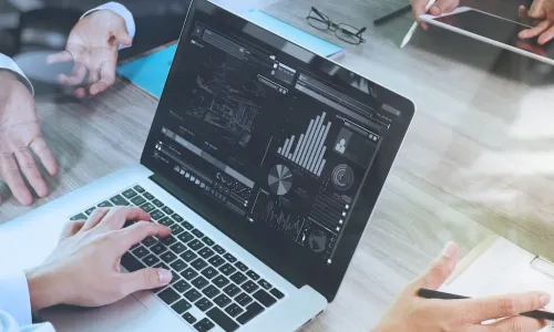 man looking at laptop display of graphical data