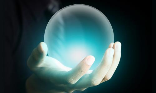 Hand of a business man holding a crystal ball glowing aqua blue