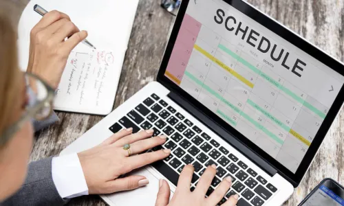 Business woman using laptop to set up calendar