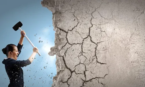 woman using sledgehammer to break down wall