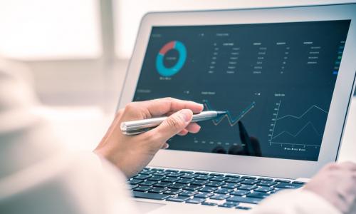 woman using a computer to consider merger financials