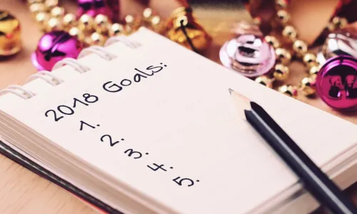 A pencil and notepad that lists 2018 goals