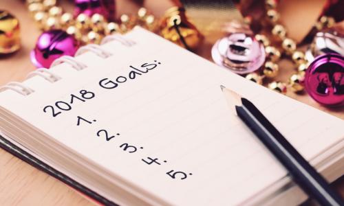 A pencil and notepad that lists 2018 goals