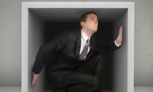 business man inside box looking uncomfortable