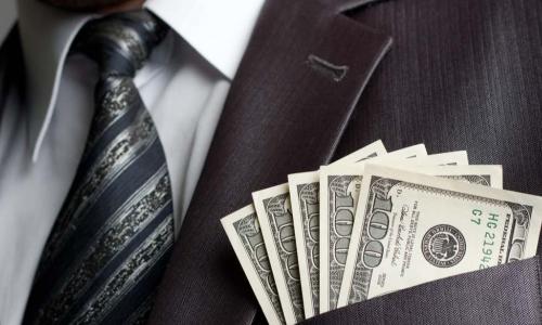 male executive with cash in his suit coat pocket