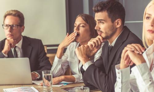 group of directors one of whom is yawning with boredom