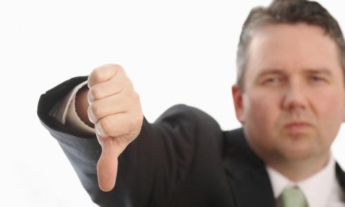 executive in green tie with thumb down