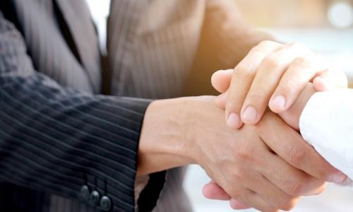 lender warmly shaking hands with business owner