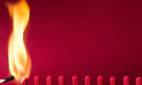 igniting a row of matches on red background