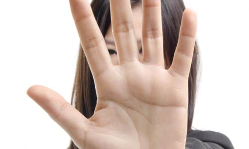 Businesswoman holding up her hand in a strong stop gesture