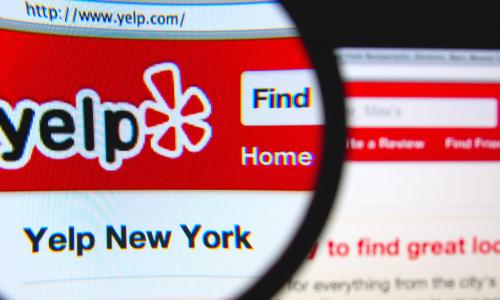 Yelp website being viewed through a magnifying glass