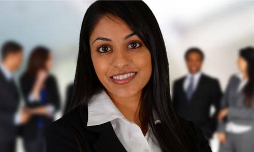 A female CEO stands in front of a group of employees