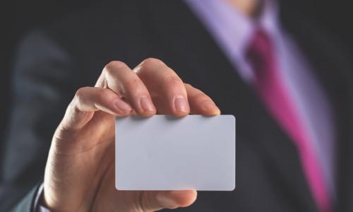 A businessman holds out a business card