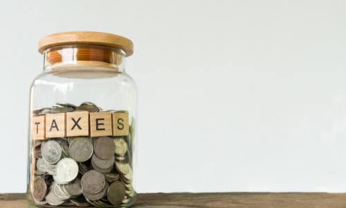 jar full of coins labeled taxes