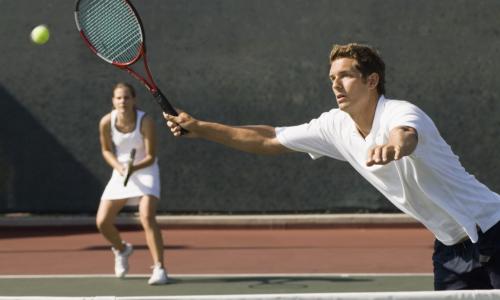 a man and a woman playing doubles tennis