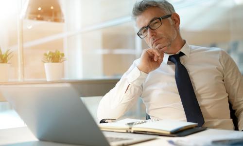 lender working with laptop, looking worried