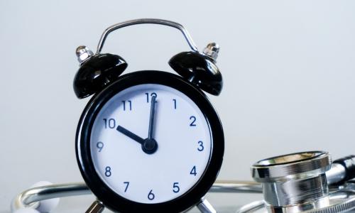 alarm clock sitting next to a stethoscope