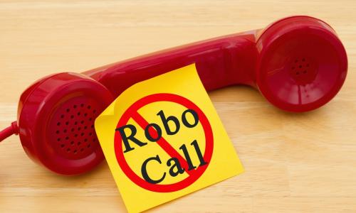 red phone with label robocall on a wooden table