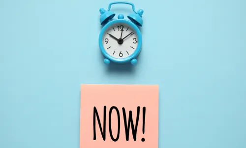 blue clock pink sticky note with word now