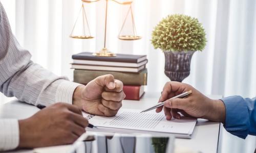 two executives with paperwork and legal scales