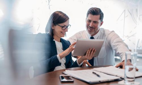 confident business people using tablet at table