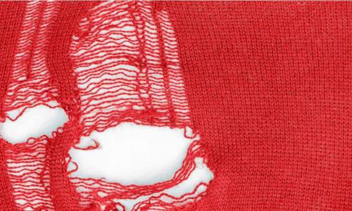 holes in red knitted fabric