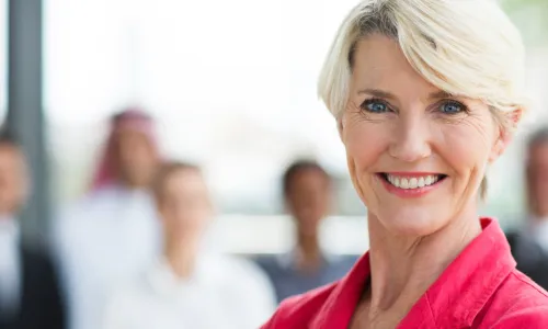 smiling senior female board member in pink blazer