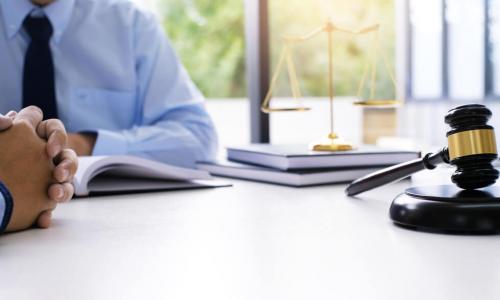 legal counsel with client at desk with gavel