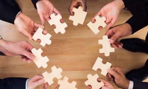 diverse business people put puzzle pieces together