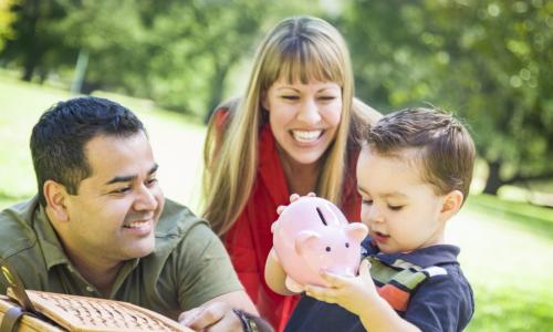 hispanic couple give their son a piggy bank