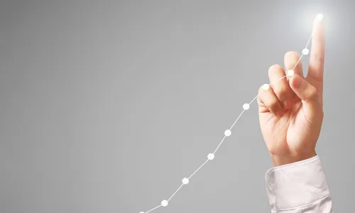 businessman pointing up to touch top data point of upward trending graph