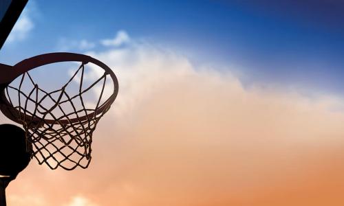 hand reaching up to catch basketball rebounding off backboard