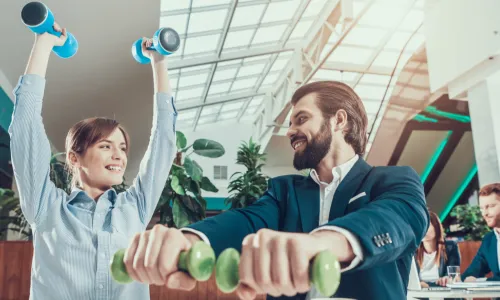 Business People in Office Interior Working with Dumbbells