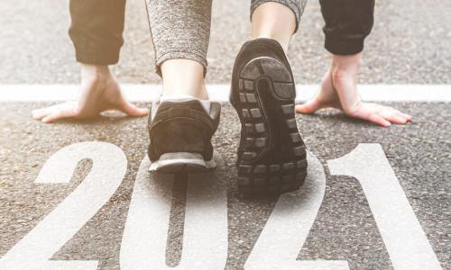 runner in black sneakers crouched at 2021 starting line