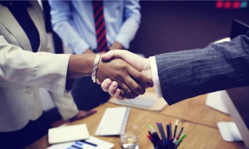 handshake of Black businesswoman and white businessman