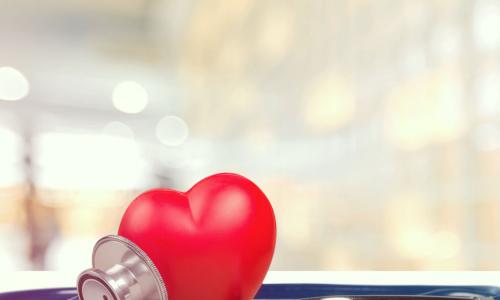 stethoscope arranged around a red heart on a table