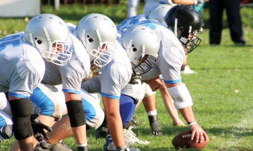 football team in blue and white uniforms playing offense