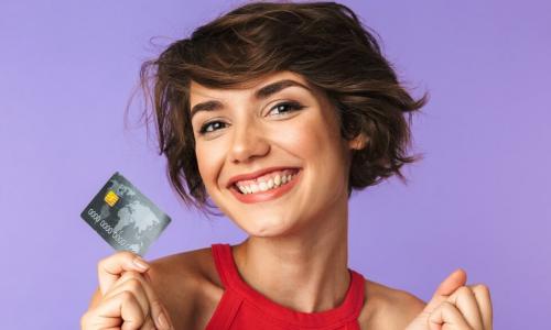 happy smiling young woman in red shirt holding credit card