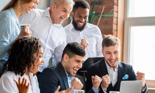 happy, diverse business people celebrating success with a laptop